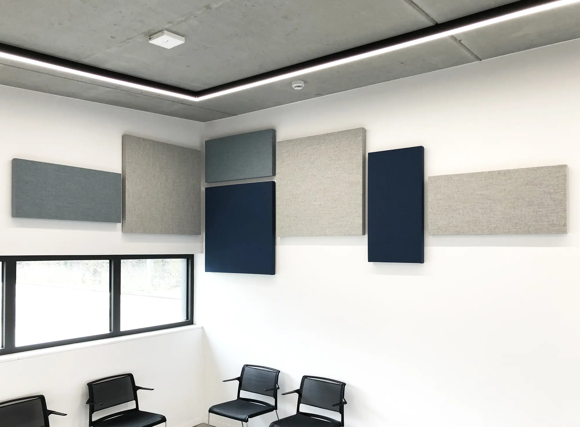 Waiting room with a composition of acoustic wall panels in grey and blue