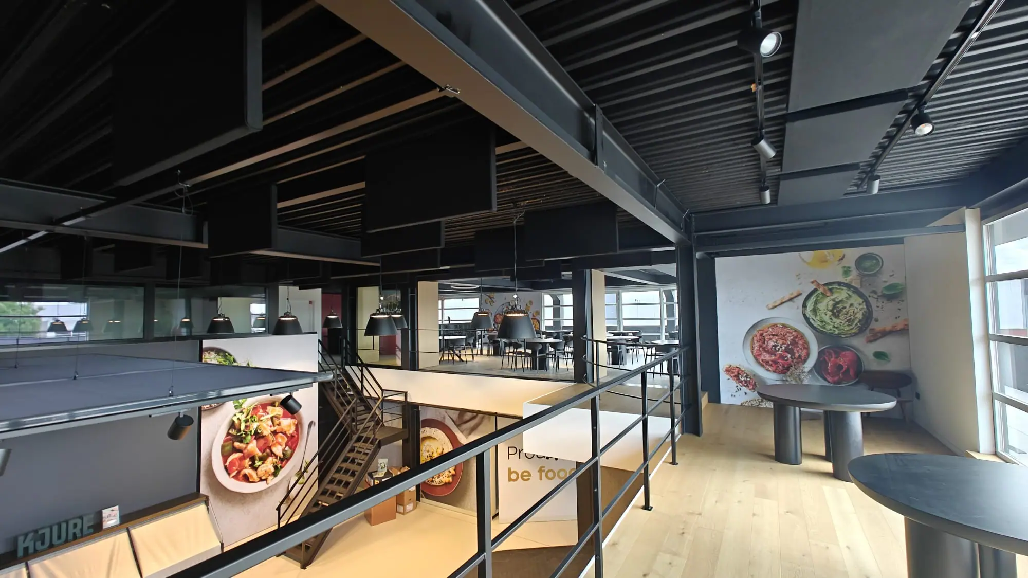 Staff restaurant with black acoustic ceiling panels on two levels