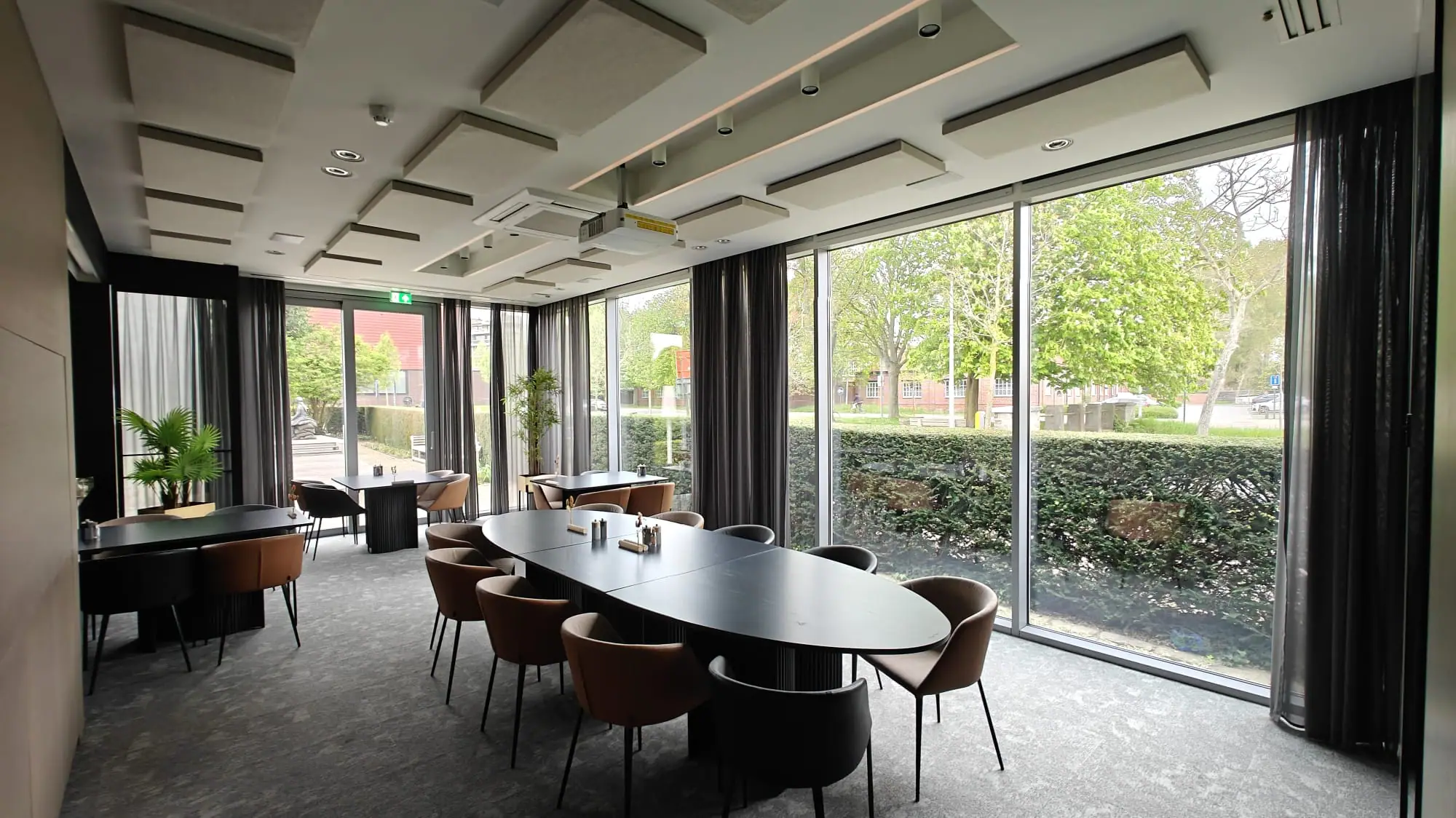 Meeting room with acoustic ceiling panels above a long table