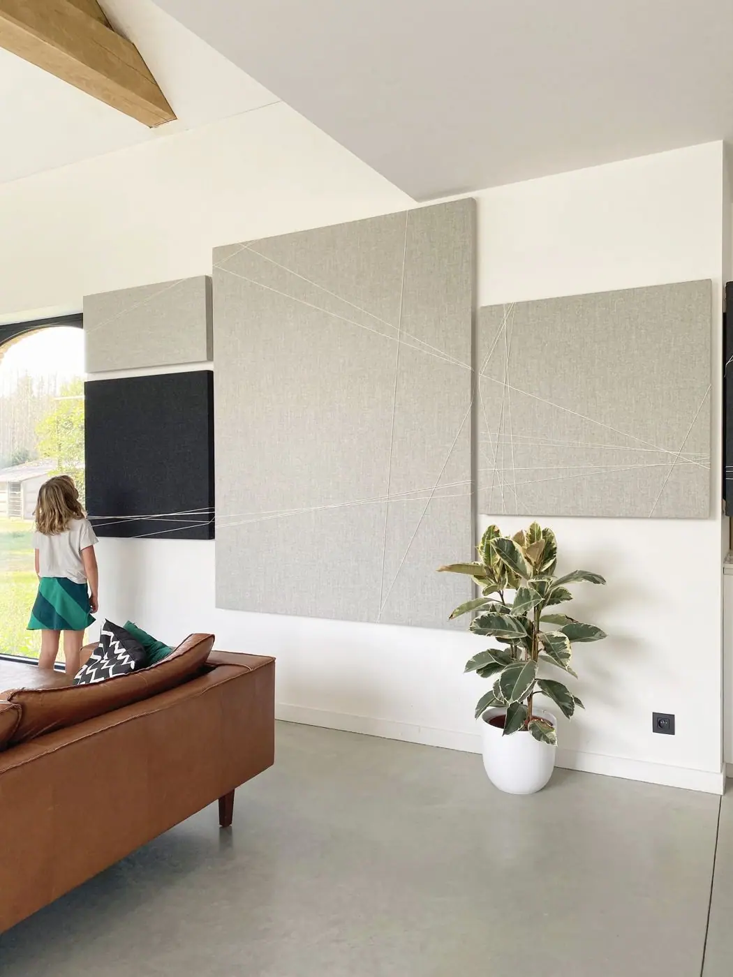 Grote artistieke wandcompositie van akoestische panelen in een woonkamer